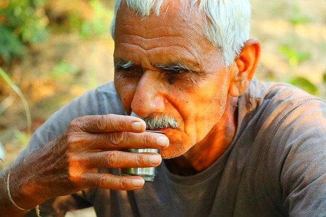 Coffee bean farmer sipping coffee while sitting on his farm